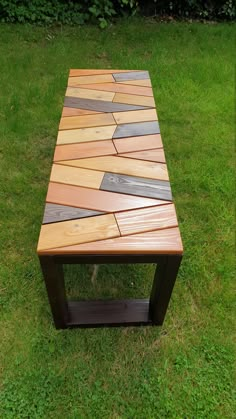 a wooden table sitting on top of a lush green field