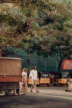 a man and woman walking down the street in front of a truck with an animal on it