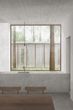 an empty room with two benches in front of a window and trees outside the window