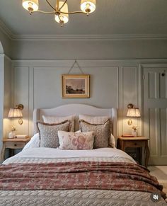 a large bed sitting in a bedroom next to two nightstands with lamps on them