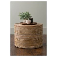 a coffee table with a plant on top and a mug sitting on it's side