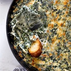 spinach dip in a skillet with bread on the side