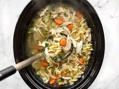 a bowl of chicken noodle soup with a spoon