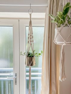 a macrame plant hanging from the ceiling next to a white door and window