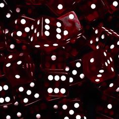 a pile of red dices sitting on top of each other with white dots all over them