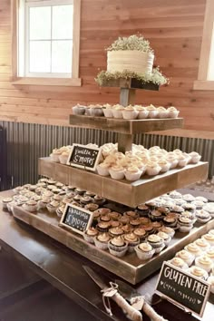 three tiered trays filled with cupcakes on top of a wooden table