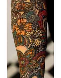 the legs are decorated with colorful flowers and swirls on their thighs, as well as an intricately designed tattoo design