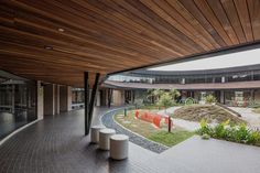 an empty courtyard in front of a building with wooden ceilinging and brick walkways