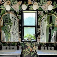 a bathroom decorated in green and white with mirrors on the wall, lights hanging from the ceiling