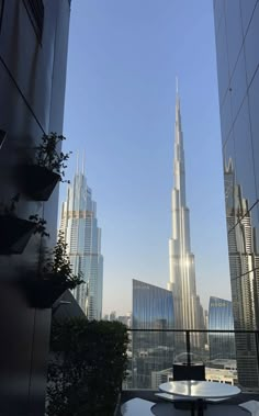 a table and chairs on a balcony overlooking the skyscrapers in downtown dubai, united kingdom