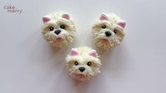 three cupcakes made to look like dogs with their faces painted pink and white