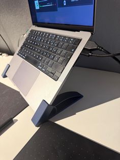 an open laptop computer sitting on top of a white table next to a black mouse