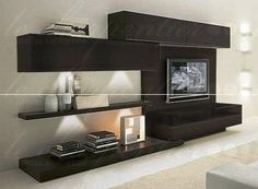 a modern living room with white walls and black entertainment center on the wall, lighted by recessed lights