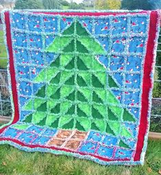 a quilted christmas tree is hanging on a fence