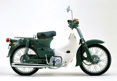 a green and white motorcycle parked on top of a white floor