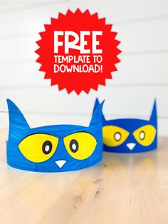 two blue and yellow paper cups with cats on them sitting on a wooden table next to a free printable sign