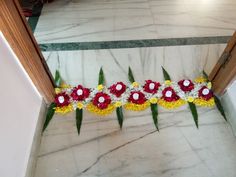 flowers and leaves are arranged on the floor in front of an entrance to a building