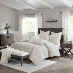 a bedroom with white bedding and wooden floors