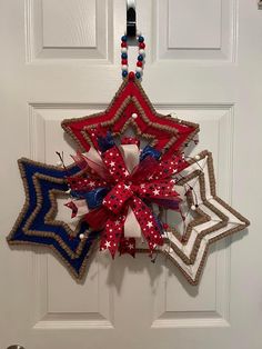 a red, white and blue star wreath hanging on a door with the word america written across it