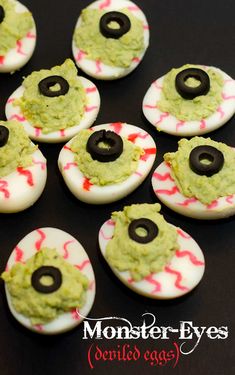 decorated devil eye cookies with green frosting and sprinkles on black surface