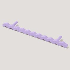 a purple plastic toothbrush holder on a gray background