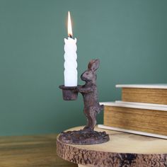 a candle that is sitting on top of a wooden table next to a stack of books