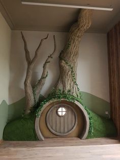 a fake hobb door in the corner of a room with trees growing out of it