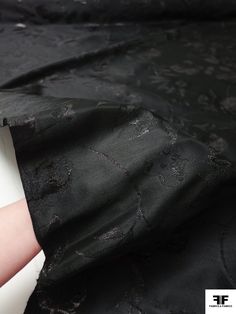 a woman's arm is wrapped in black fabric