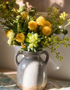 a vase filled with yellow flowers on top of a table