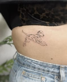 a woman's stomach with a dog tattoo on her lower back and the side