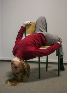 a woman is upside down on a chair