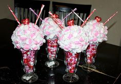 three vases filled with candy canes on top of a table