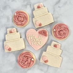 decorated cookies are arranged in the shape of hearts and flowers on a marble table top