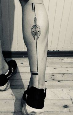 a woman's legs with an arrow tattoo on them