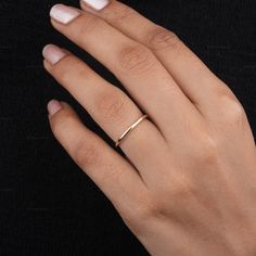 a woman's hand with a gold ring on it