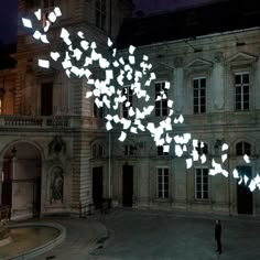 a person standing in front of a building with lots of white lights on the ceiling