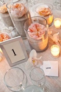 the table is set with candles and flowers in glass vases, which are labeled 1