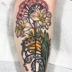 a tattoo with flowers on the leg