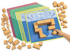 a person is playing with wooden blocks on the floor and in front of them are several pieces of cardboard