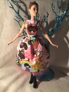 a barbie doll wearing a colorful dress with trees on it