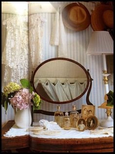 a table topped with a mirror next to a lamp