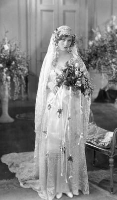 an old black and white photo of a woman in a wedding dress