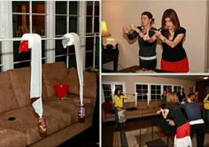 two women playing wii in a living room with other people watching and drinking beverages on the couch