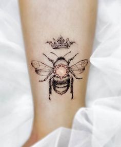 a bee with a crown tattoo on it's leg is seen in this image