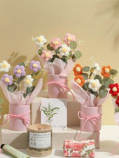 flowers are in vases on a table next to some wrapping paper and other crafting supplies