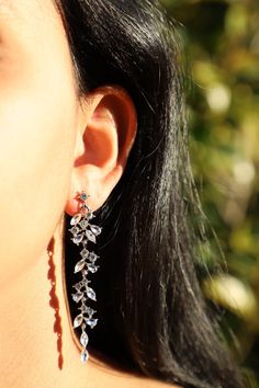 a close up of a woman's ear wearing earrings with flowers on the side