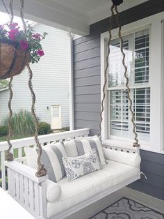 a white porch swing with flowers on it