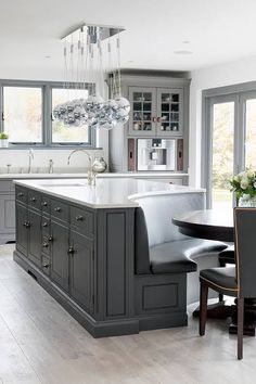 a kitchen with gray cabinets and white counter tops