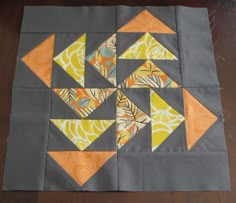 an orange and gray quilted block with several different designs on it