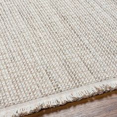 a close up view of a rug on a wooden floor with the edge of it